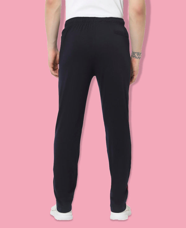 Person wearing black sweatpants on a pink background