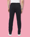 Person wearing black sweatpants on a pink background